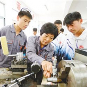 江蘇東海中等專業(yè)學(xué)校的老師在車床旁向?qū)W生講解工件如何打表